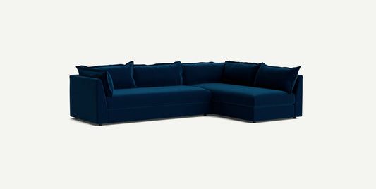 The Denver Two Piece Velvet L Shaped 119" Sectional in modern dark blue features a right-hand chaise and comes with matching cushions, all set against a light background.