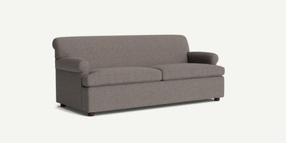 The Willoughby Sleeper Sofa features a simple, modern design with a gray color, rounded armrests, and cushioned backrest and seat. It is presented against a plain light background and showcases its minimalist aesthetic with small wooden legs.