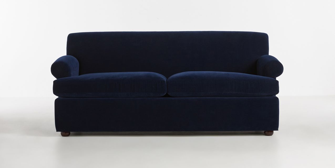 The Willoughby Sleeper Sofa features a stylish navy blue design with two seat cushions and rounded armrests, set against a plain white background.