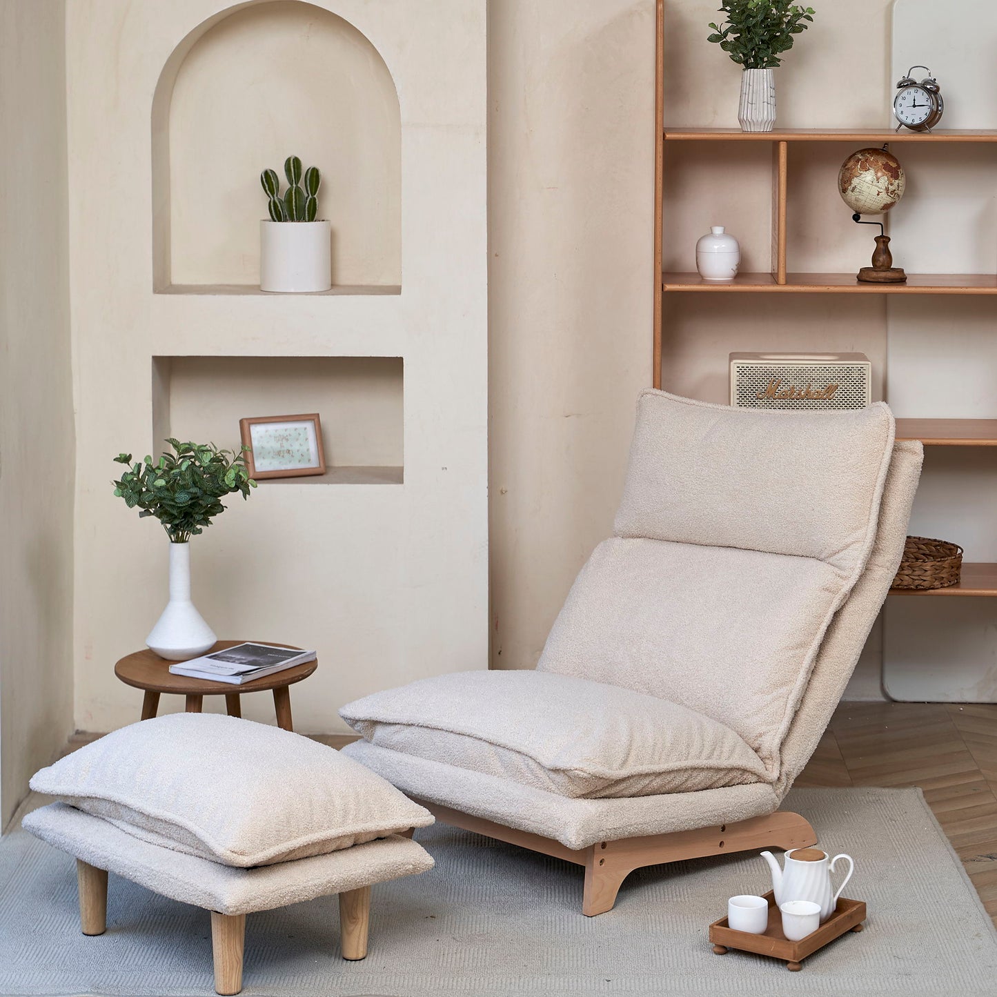 Cozy room featuring a Single Lazy Sofa Chair Leisure Foldable Reclining Chair in beige on a light rug, paired with a matching ottoman. Nearby, a small wooden table holds plants and a picture frame. In the background, a wooden shelf displays decor items like a globe and more plants.