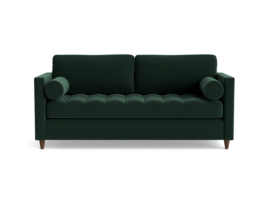 The Briar Sleeper Sofa is a dark green, mid-century modern piece featuring two cylindrical arm cushions and tufted seating. It is elevated on short wooden legs and presented against a plain black background.