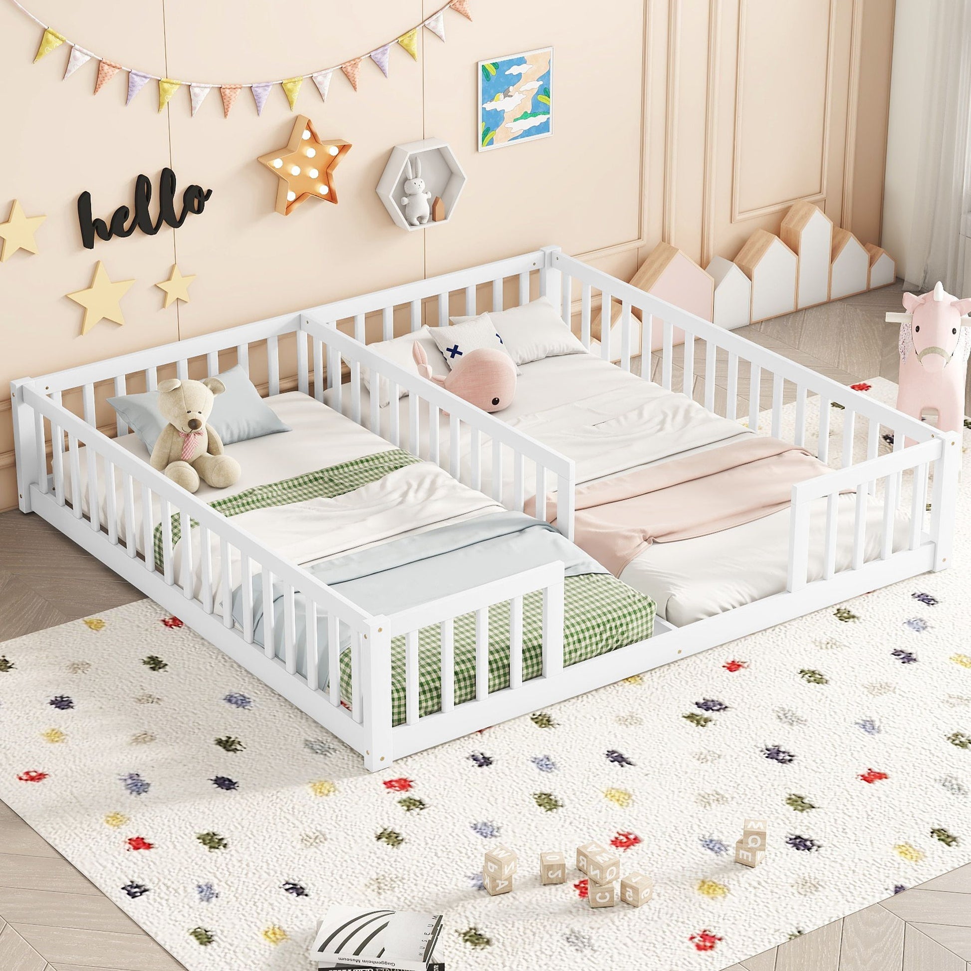 A children's bedroom showcases two Double Floor Beds With Fence and Guardrails. Pastel bedding, a soft, colorful rug, hanging stars, a "hello" sign, and toy shelves enhance the space with playfulness and coziness.