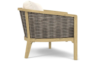 A side view of the Parkside Outdoor Sofa showcases its wicker construction, featuring a light wooden frame and a beige cushion. The modern design includes a slightly reclined backrest.