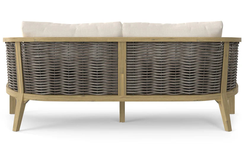 Back view of the Parkside Outdoor Sofa, showcasing its woven wicker design with a wooden frame and light beige cushions. It features a curved back and tapered legs, combining rustic charm with modern style.