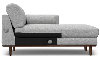 Introducing the Morrison Mid Century Sectional in Genuine Leather: a contemporary gray chaise lounge with thick cushioning, a coordinating backrest, and sturdy wooden legs. The design incorporates sleek black accents on the lower section for a chic, minimalist aesthetic.