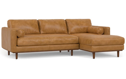 The Morrison Mid Century Sectional in Genuine Leather is a brown L-shaped leather sofa with wooden legs, featuring three seat cushions and three back cushions. It includes two matching bolster pillows, and the chaise is conveniently positioned on the right side.