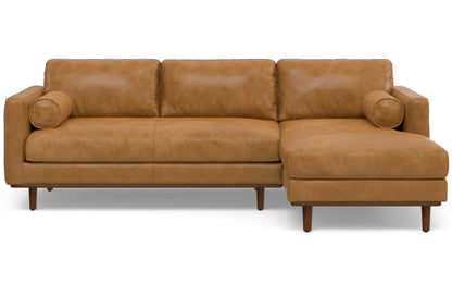 The Morrison Mid Century Sectional in Genuine Leather is a brown leather sectional sofa featuring a chaise lounge on the right side. It includes three seat cushions, three back cushions, and two cylindrical arm pillows, all supported by wooden legs.