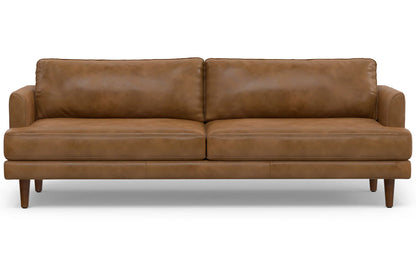 The Livingston 90-Inch Mid Century Sofa is a brown leather piece with a sleek design, featuring two seat cushions, two back cushions, and wooden legs. This sofa exudes a modern and comfortable ambiance, making it perfect for a stylish living room.