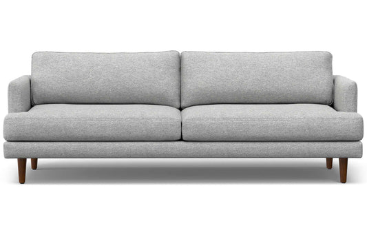 The Livingston 90-Inch Mid Century Sofa is a modern piece featuring clean lines, light gray upholstery, and wooden legs. It includes two seat cushions and two back cushions, embodying a minimalist and contemporary design.