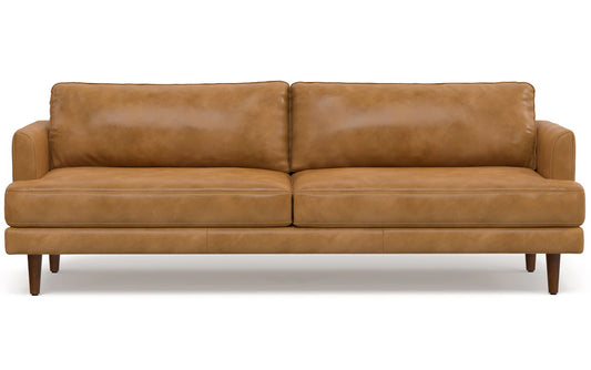 The Livingston 90-Inch Mid Century Sofa, crafted in tan leather, boasts a modern design with two large cushions and tapered wooden legs. Its sleek and minimalist appearance makes it an ideal choice for contemporary living spaces.