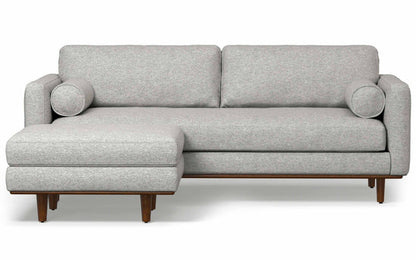 Introducing the Morrison 89-Inch Sofa and Ottoman Set in Genuine Leather: a contemporary gray sofa with a left-side chaise lounge, complete with two cylindrical cushions and wooden legs, offering a minimalist and stylish design.