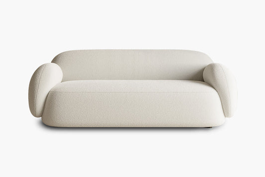 Introducing the Dori Sofa by Acanva: a contemporary light beige sofa boasting rounded, plush armrests and a sleek minimalist design. It is crafted with textured fabric and features a low backrest, all showcased against a simple white background.