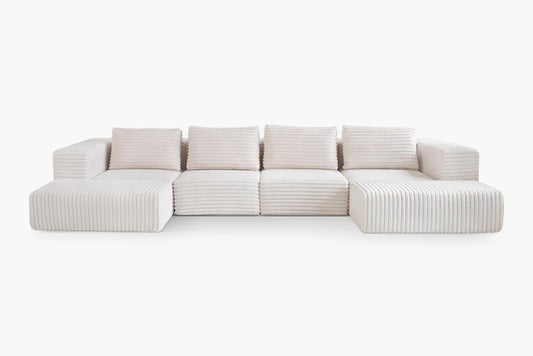 The Atlas Modular Sofa by Acanva is a contemporary sectional sofa featuring off-white ribbed upholstery, square cushions, and a low-profile design. It is composed of five interconnected segments, making it ideal for a spacious living area.