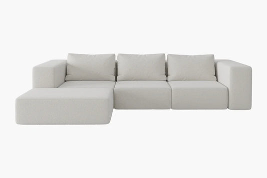 The Atlas Modular Sofa by Acanva is a modern, light gray sectional with square cushions and blocky armrests, featuring a chaise lounge on the left side. Its minimalist design perfectly complements a contemporary living space.