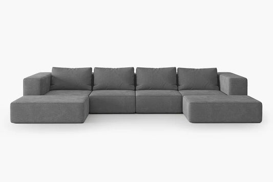 The Atlas Modular Sofa by Acanva is a spacious gray sectional sofa featuring multiple cushions and a low profile. It is set against a plain white background, showcasing its minimalist design composed of square and rectangular segments.