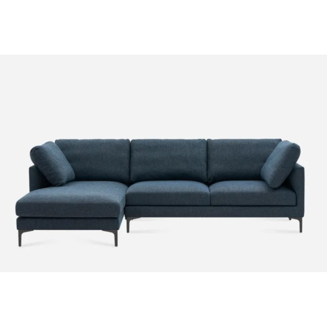 Dark blue sectional sofa with a modern design, featuring a left-hand chaise, three seat cushions, and four cylindrical back cushions. The sofa has sleek black legs and is set against a plain white background.