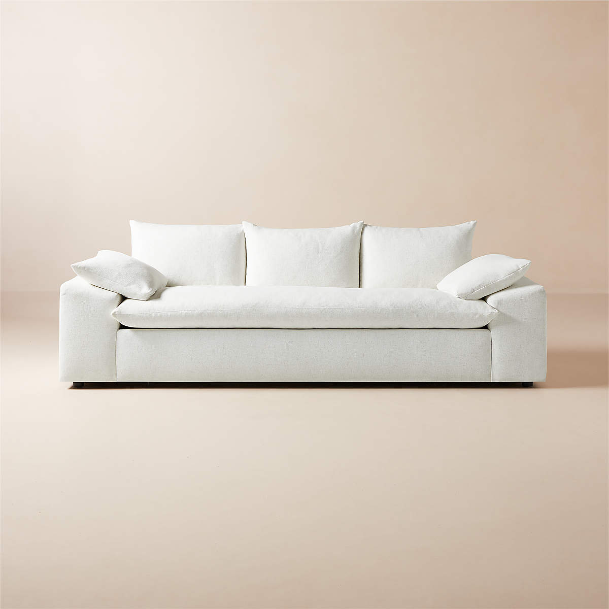 The Algora 100" White Performance Fabric Sleeper Sofa is set against a neutral beige background, showcasing a minimalist design accentuated with three cushions and two armrest pillows. Its clean lines contribute to a cozy and elegant appearance.