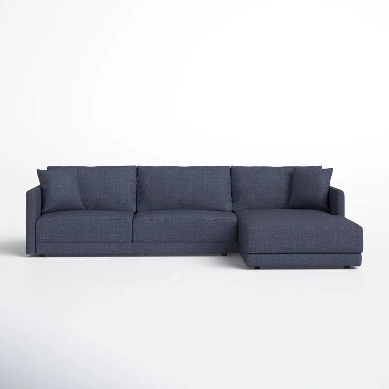 The Astra 2-Piece Upholstered Sectional is a modern, dark blue sofa featuring three cushioned seats and a chaise lounge on the right. Its clean, simple design is highlighted against a plain white background.