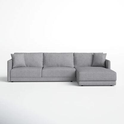 The Astra 2-Piece Upholstered Sectional, featuring a modern gray design with three seat cushions and a right-side chaise lounge, is set against a plain white background.