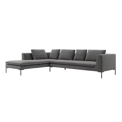 The Charles Left Arm Sectional Sofa by B&B Italia is a modern L-shaped piece upholstered in dark gray fabric, accented with thin black legs and featuring three back cushions plus a chaise lounge on the left side.