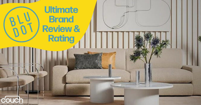 Contemporary living room with a beige sofa, colorful throw pillows, two round white coffee tables, and a wall decoration. The image has a yellow overlay text reading "BLU DOT Ultimate Brand Review & Rating.