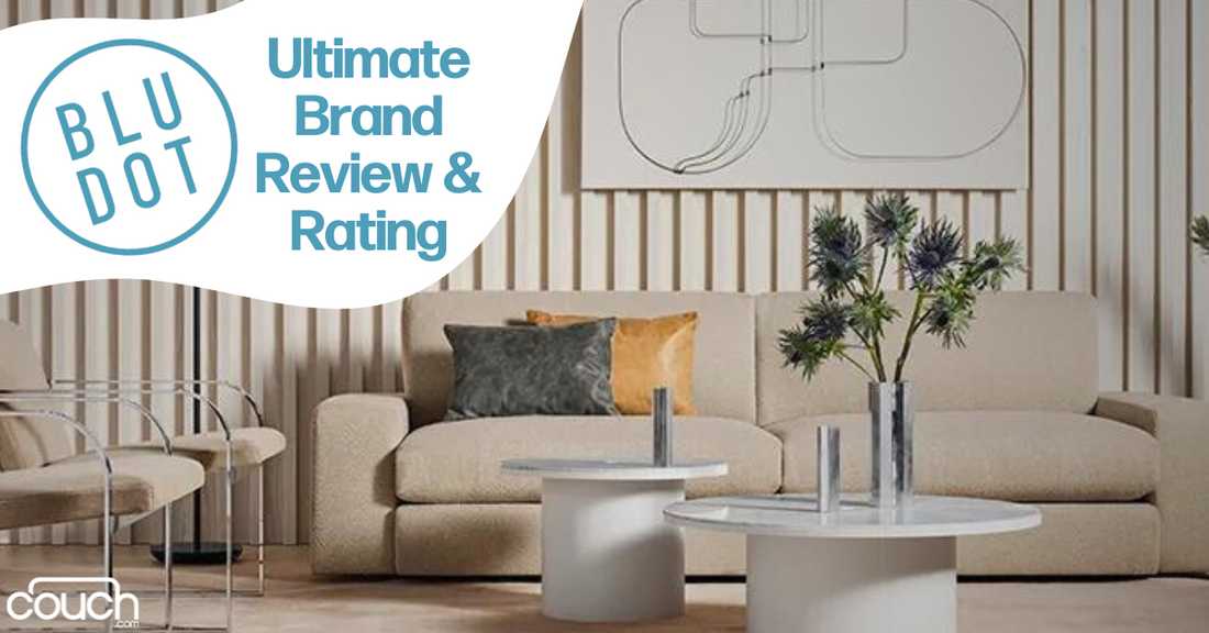 A modern living room featuring a light beige sofa, two white round coffee tables, and minimalist wall art. Decorative vases with greenery sit on the tables. Text reads "BLU DOT Ultimate Brand Review & Rating" on the top left corner with the Couch brand logo.