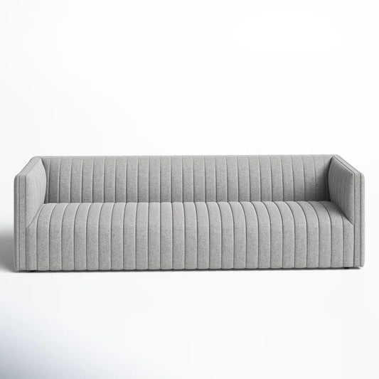 The Brandt 97'' Upholstered Sofa is a contemporary gray piece with vertical tufted upholstery, showcasing clean lines and a minimalist design, placed against a plain white background.