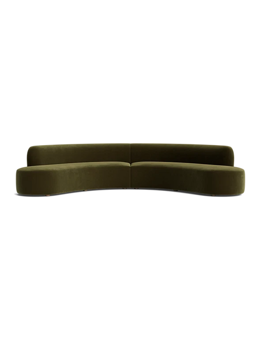 A sleek, modern Cara Sectional Sofa in dark green velvet with a curved design is set against a plain black background. The sofa features a minimalist style with no visible legs and a smooth, continuous backrest.