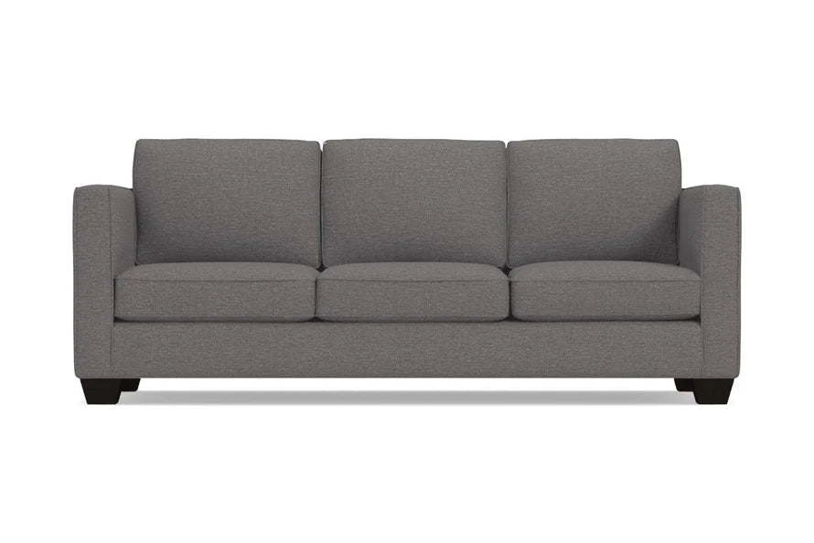 The Catalina Sofa is a stylish grey three-seater featuring square arms and dark wooden legs, all displayed against a plain white background. Its clean lines and modern design make it a chic addition to any space.