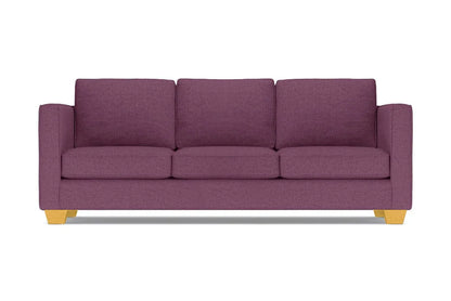 The Catalina Sofa, with its modern design in a purple hue, comes complete with three cushions. It features straight arms and light wooden legs, all showcased against a white background.