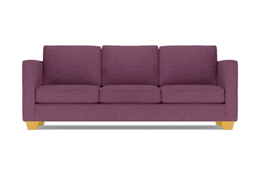 The Catalina Sofa, with its modern design in a purple hue, comes complete with three cushions. It features straight arms and light wooden legs, all showcased against a white background.