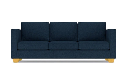 The Catalina Sofa is a dark blue three-seater featuring square cushions and light wooden legs, set against a white background.