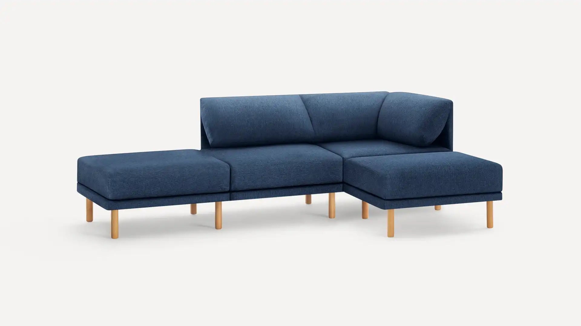 Experience the modern elegance of the Range Fabric 4-Piece Open Sectional Double Lounger Sofa, featuring a deep blue fabric upholstery and light wooden legs against a plain white background. This sofa boasts clean lines and a minimalist design, complete with an outward-extending chaise section.