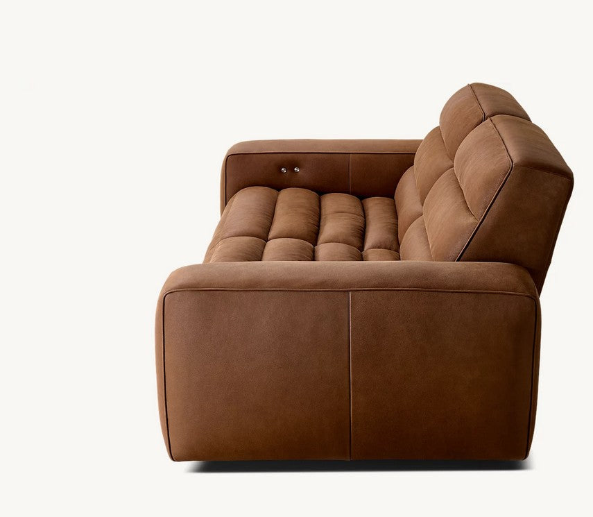 A side view of the Chelsea Motion Leather Modular 2-Piece Recliner Sofa reveals its modern design with plush, cushioned upholstery in a rich brown leather. The smooth surface features subtle stitching details, and both the backrest and seating area are slightly tilted to enhance comfort.