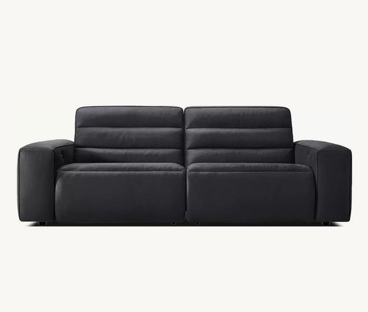 The Chelsea Motion Leather Modular 2-Piece Recliner Sofa is a contemporary black two-seater with wide armrests and plush, cushioned backrests. It boasts a sleek, leather-like finish and is showcased against a plain white background.