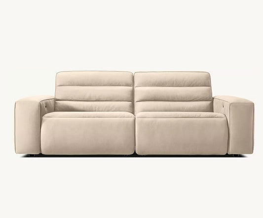 A beige, modern Chelsea Motion Leather Modular 2-Piece Recliner Sofa with a minimalist design. The cushions are accented with horizontal stitching, and the armrests include convenient cup holders. The sofa is set against a plain, light background.