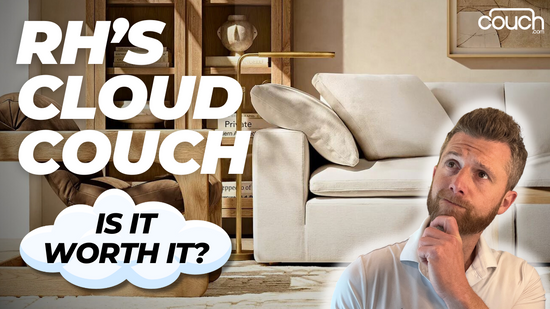 A man with a thoughtful expression stands near a white couch with plush cushions. Large text reads "RH's Cloud Couch, Is It Worth It?" The background shows wooden shelves with books and decor items. The "c" in "couch" is stylized as a minimalist chair logo.