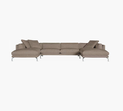 The Como Sectional Sofa is a contemporary taupe-colored design with clean lines and sleek metal legs, complete with a chaise on one end and several coordinating cushions, all showcased against a plain white background.