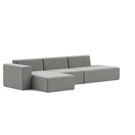 The Three-Seater Form Sectional is a contemporary, minimalist sofa in grey, featuring three seats and a chaise lounge on the left. Its design showcases clean lines and a low profile, all highlighted against a simple background.