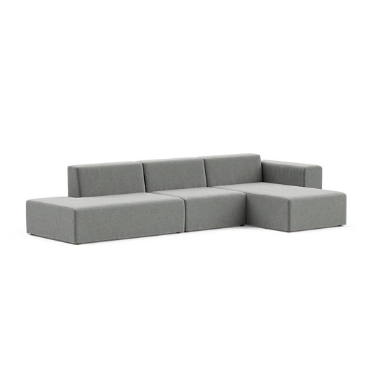 The Three-Seater Form Sectional is a minimalist gray L-shaped sofa featuring clean lines and a low-profile design. Set against a plain white background, it highlights its sleek and modern appearance.