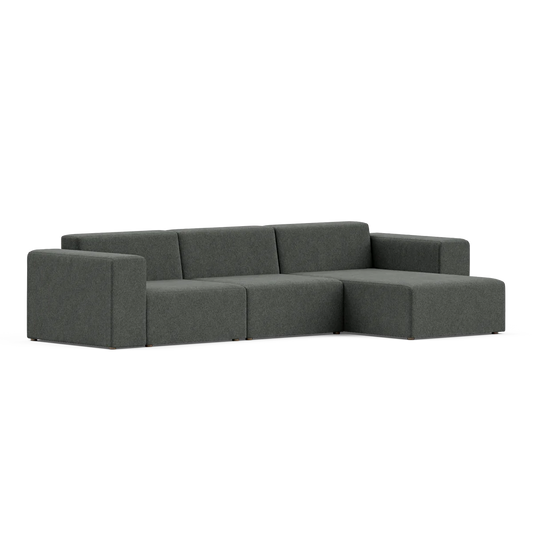 A contemporary dark gray Three-Seater Form Sectional featuring a minimalist design and right-hand chaise is positioned against a plain white background, accentuating its clean lines and modern style.