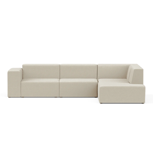 The Four-Seater Form Sectional is a spacious, contemporary beige sofa with a sleek, minimalist design. It boasts clean lines and an inviting appearance with a right-facing chaise lounge, set against a simple black backdrop.