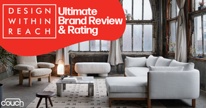 An industrial-style living room with a large window, modern white sectional sofa, ottoman, and coffee table on a patterned rug. Text reads "DESIGN WITHIN REACH Ultimate Brand Review & Rating" with the Design Within Reach logo and couch.com logo.