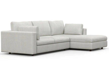 The Daphne Chaise 96" Sofa is a contemporary sectional in light gray, featuring three large back cushions and a right-side chaise lounge. It showcases clean lines and low-profile feet, all set against a plain white background.