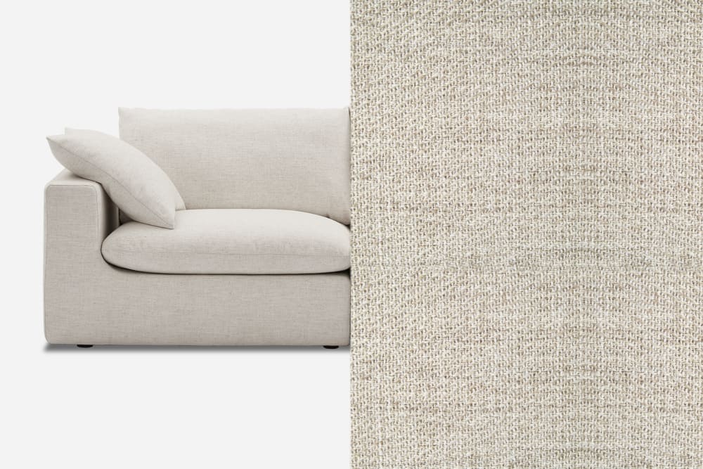 A modern beige sofa with a minimalist design is shown on the left. The right side features a close-up of the sofa's fabric, highlighting its texture and color. The sofa has a plush cushion and a simple, clean-lined armrest.