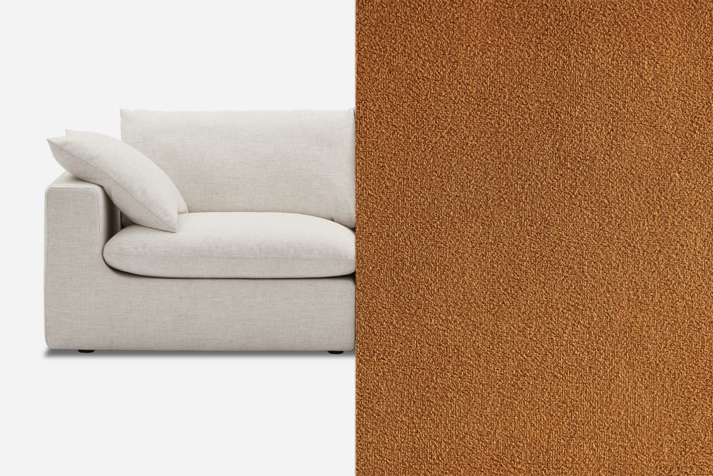 A light gray sofa with soft cushions is partially covered by a large brown textured fabric swatch on the right side, displaying the fabric's surface detail. The background is a plain white.