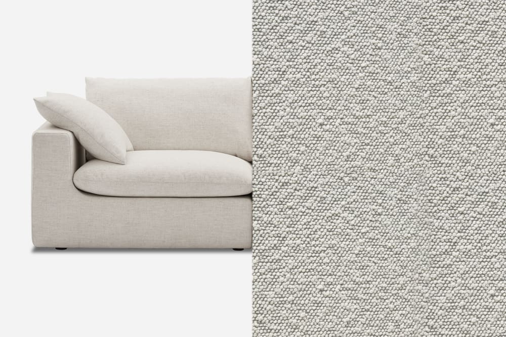 Close-up of a modern, light beige fabric sofa with a square armrest and cushion. The left side of the image shows the sofa, while the right side displays a detailed view of the fabric's texture, featuring small, even pebbled patterns.