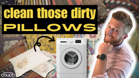 A man smiles while pointing to text that reads "clean those dirty pillows." The background shows a variety of patterned fabrics with a washing machine and two pillows in front. The bottom left corner has the word "couch" in a white logo.