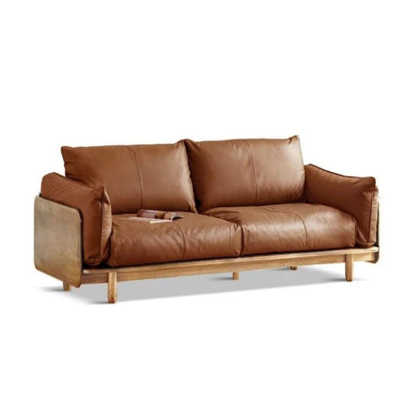 The Elwood 9-Seater Sofa, featuring a brown leather upholstery with plush cushions and a wooden frame, is showcased on a white background. A magazine rests on the left cushion.