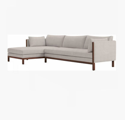 Introducing the Emmy Sectional, a contemporary L-shaped sofa featuring light gray upholstery and elegant wooden legs. It includes a left-side chaise and plush cushions for both seating and backrest comfort.